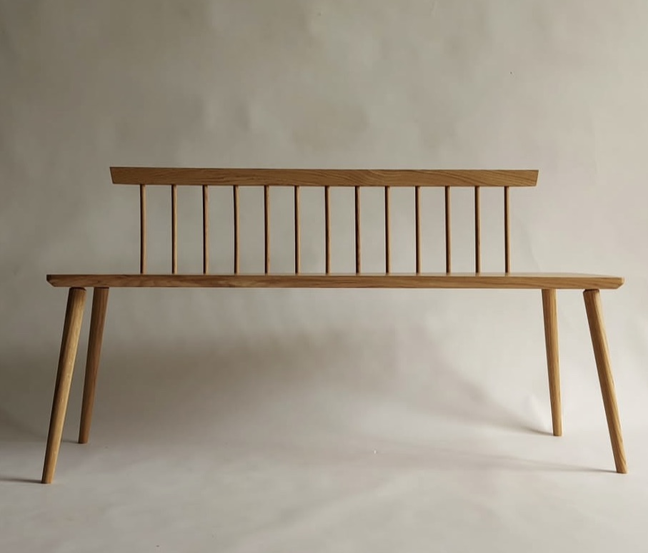 A solid oak bench seat with turned legs and through tenons.